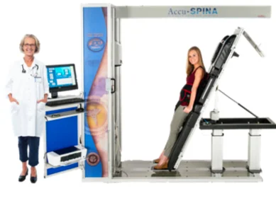 Doctor standing beside AccuSPINA spinal decompression device with patient lying on traction table