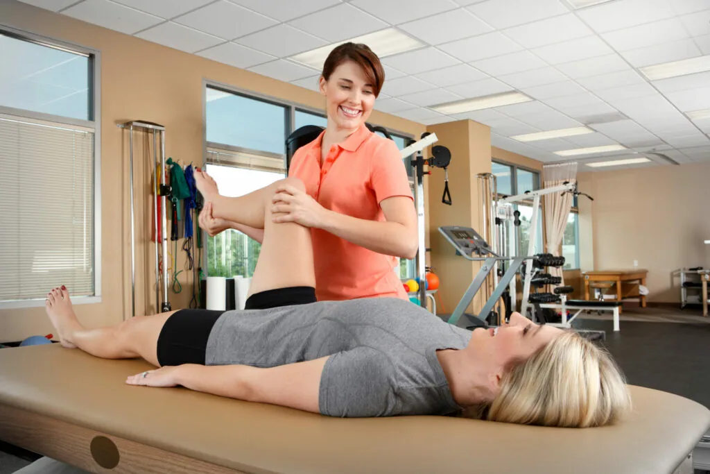 Physical therapist performing arm mobility assessment on patient lying on treatment table in clinical setting