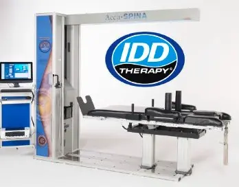 The Accu-SPINA IDD Therapy table lowered flat, beside its computer console